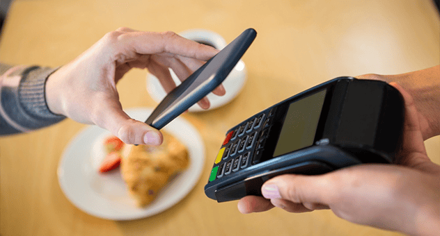 A woman making payment with her phone in a restaurant.png