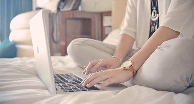 woman-sitting-on-bed-surfing-the-internet