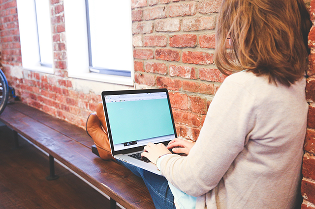 woman-sitting-relaxed-writing-on-laptop