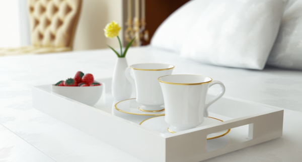 image-of-tray-with-two-cups-of-tea-with-a-bowl-of-strawberries-and-a-flower-in-vase-on-the-bed-in-a-hotel-room