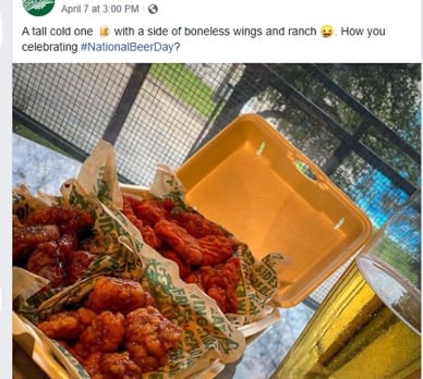 Chicken wings in takeaway with pint of beer